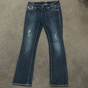 Blue light wash, slim boot cut jeans with slight rips on upper thigh.
